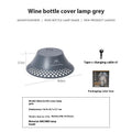 Beige and grey repurposed wine bottle camping lanterns with a gear switch on top for adjusting light mode.