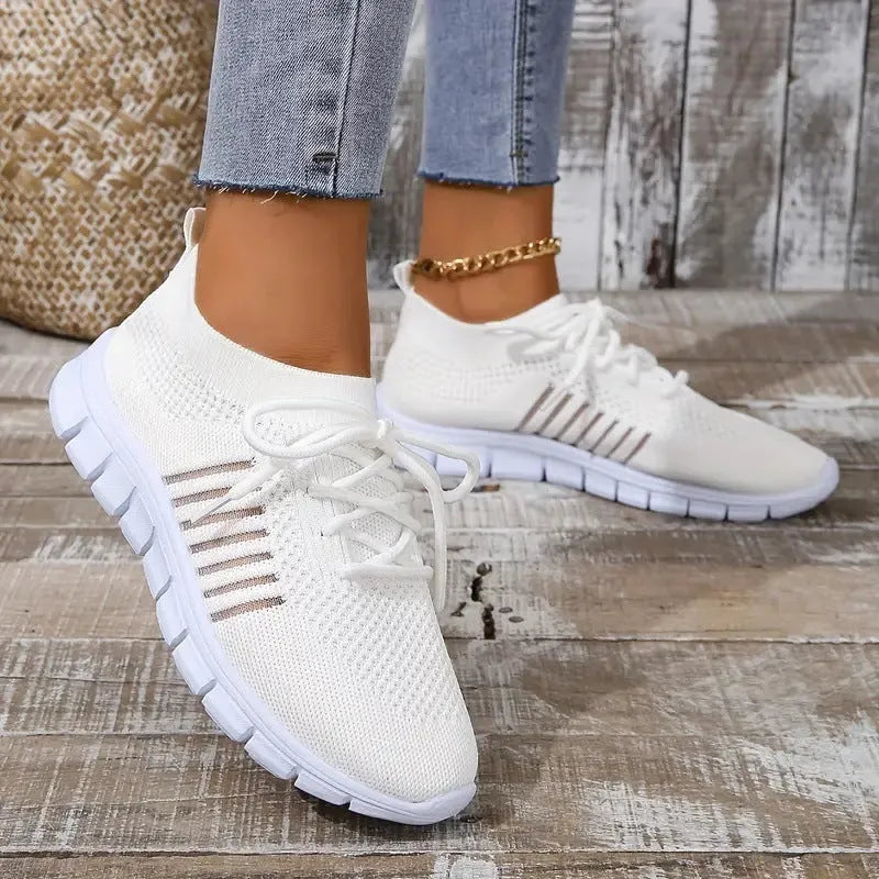 Women's casual flying knit mesh sports flat shoes in a light colour with front lace-up design.