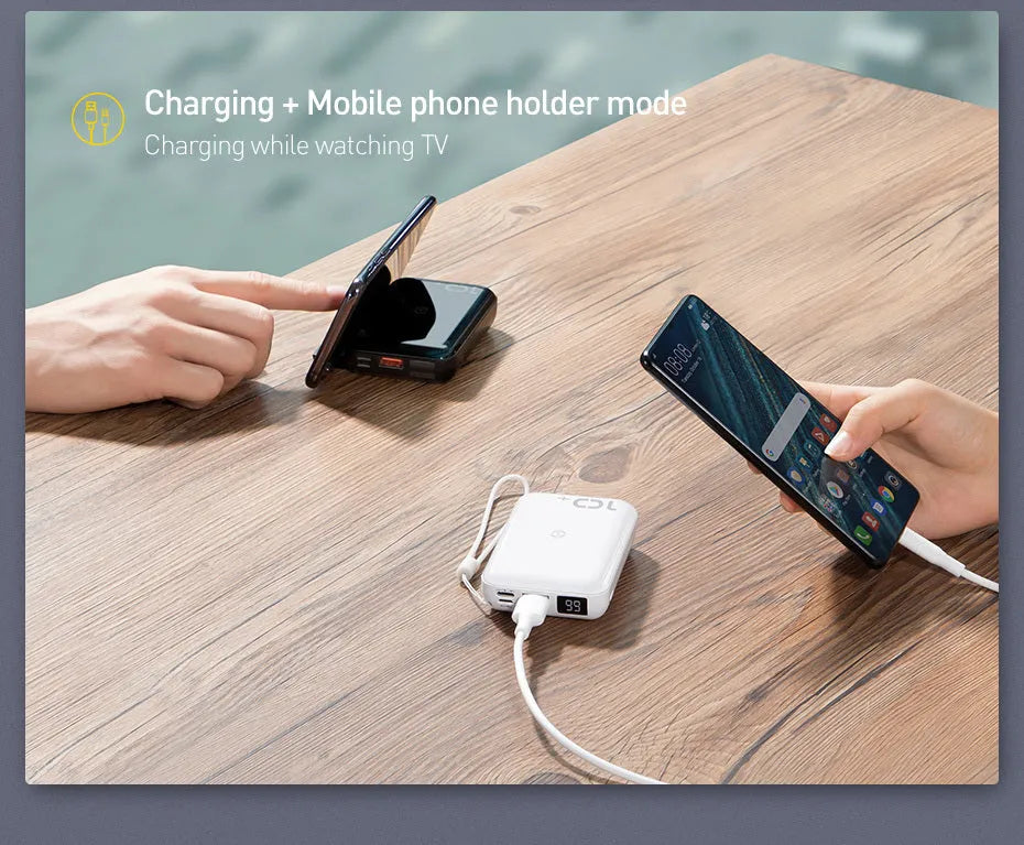 Small square black portable power bank with LED digital display on a table.