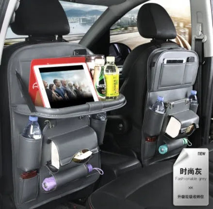 Black PU leather car seat organiser with multiple pockets hanging on a car headrest
