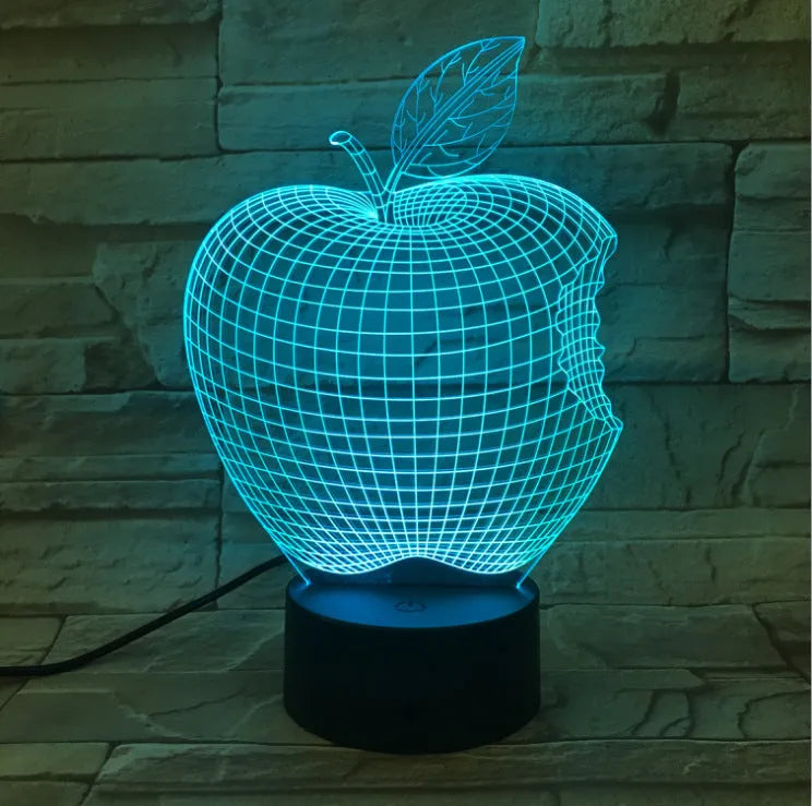 Colour-changing fruit-shaped acrylic night light with touch control on a surface.