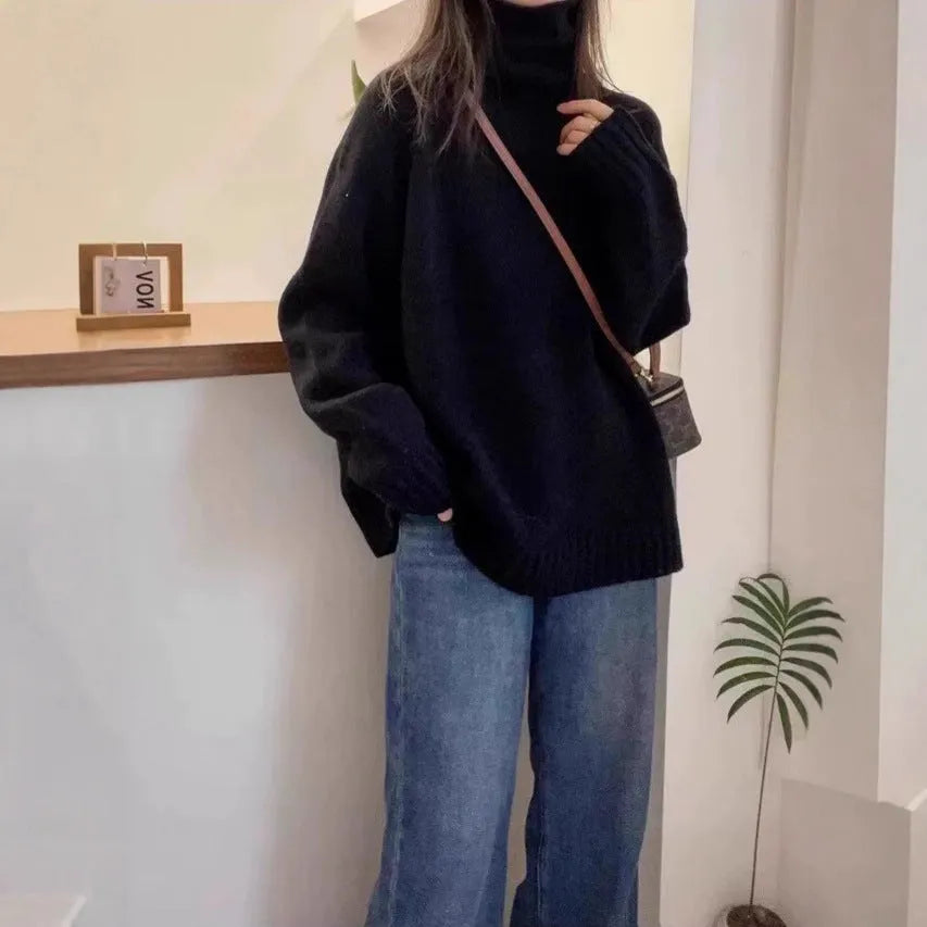 Women's loose grey turtleneck sweater with a thick curling pile collar and 3D pattern texture.