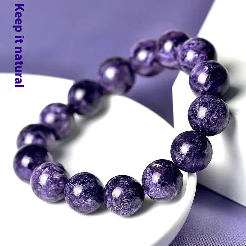Close-up of a Charoite crystal beaded bracelet with a platinum setting, showing the detailed stone pattern.