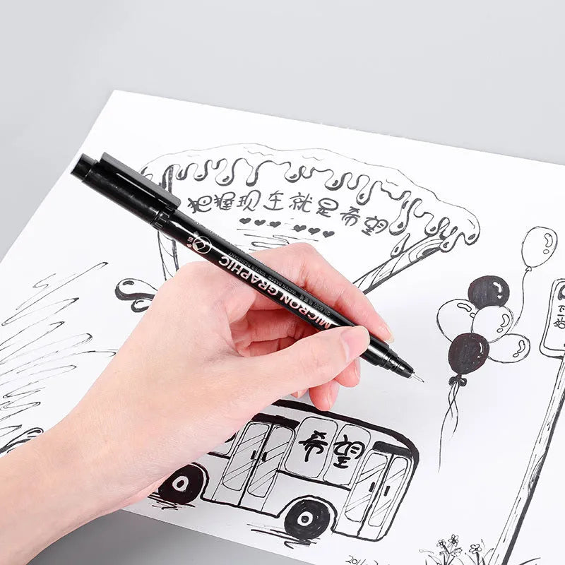 Set of black comic drawing pens with multiple nib sizes in a storage bag organiser.