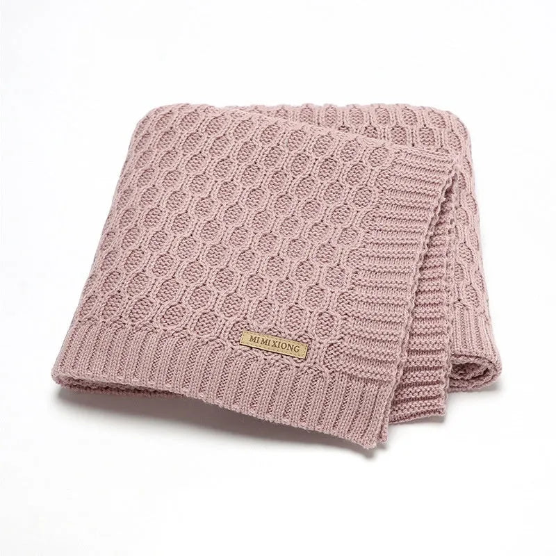 Solid colour infant hug blanket with three-dimensional lines, shown in one of five colour options.