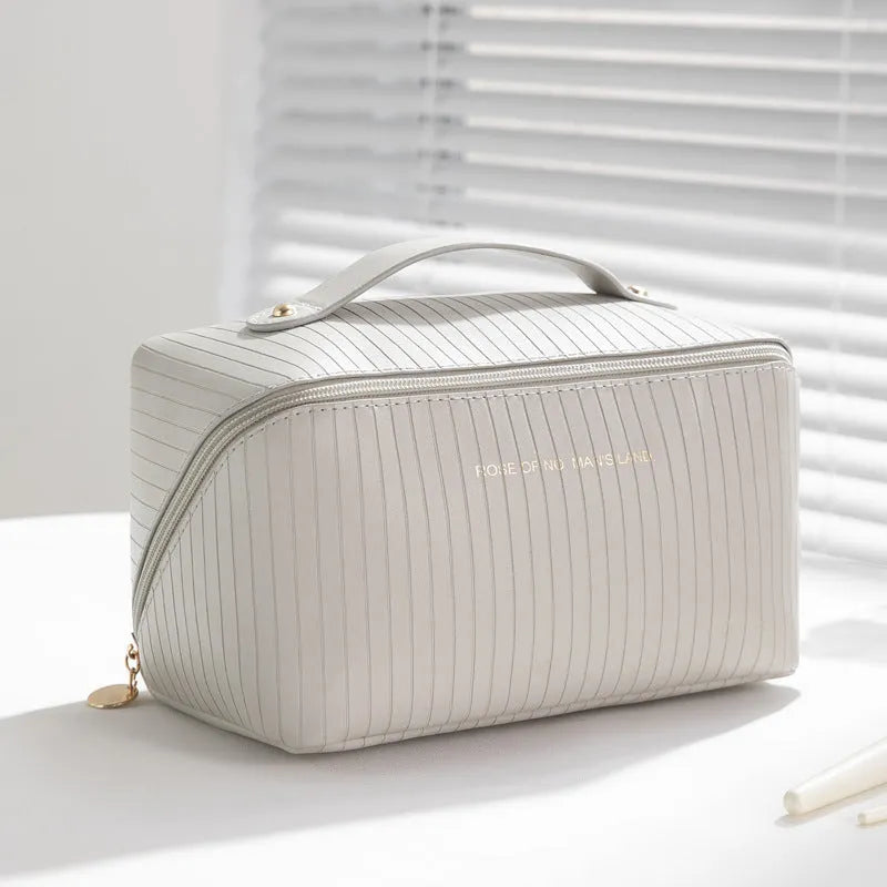 Vertical pattern cubic PU makeup bag in beige, showing large capacity for travel storage.