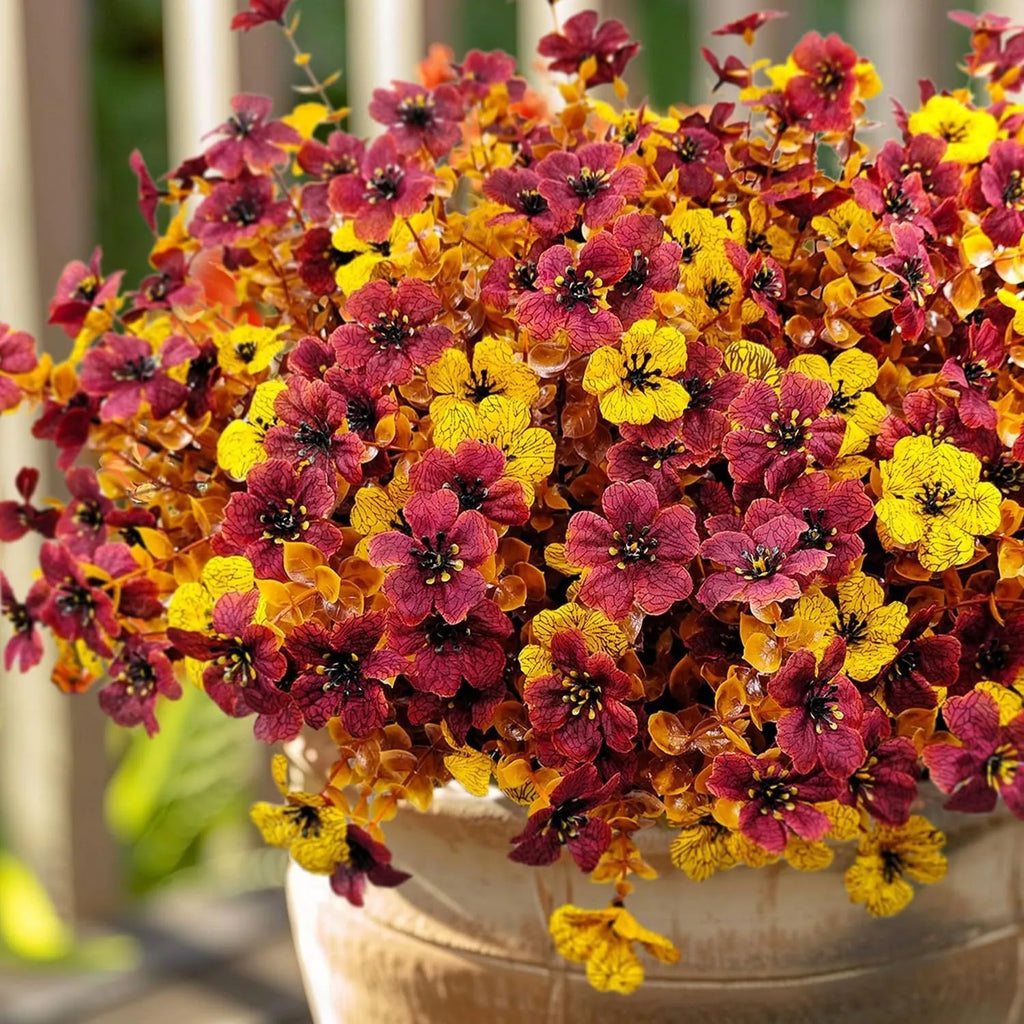 Artificial silk flower bouquet in autumn red, yellow, and orange colours for home or wedding decoration.