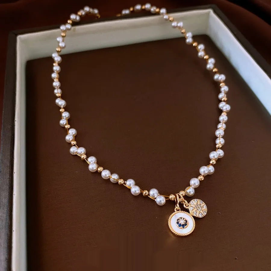 Gold electroplated round pendant necklace with zircon accents on clavicle chain