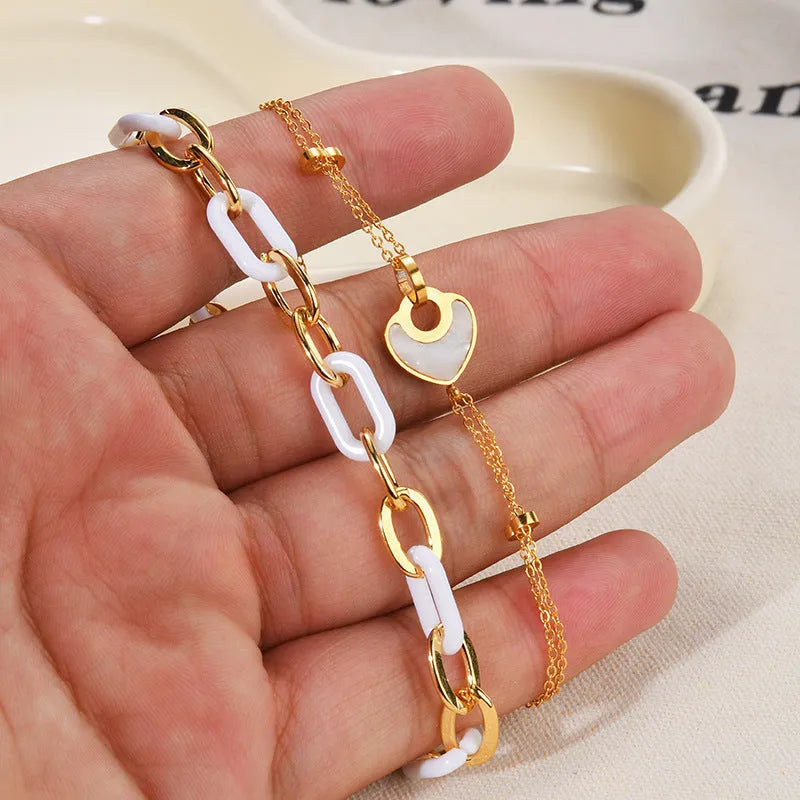 Close-up of a women's stainless steel bracelet with a double-layered heart pendant.