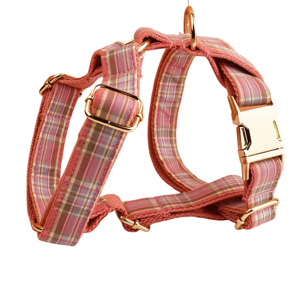 Plaid cloth dog collar and leash set with matching vest and decorative bow.