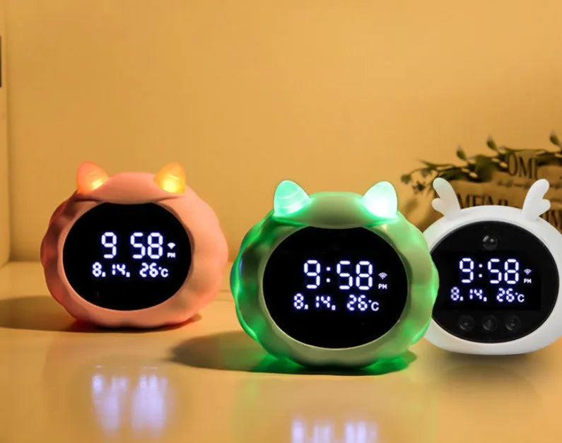 Smart alarm clock with silicone shell, luminous display, featuring voice and motion sensor controls.
