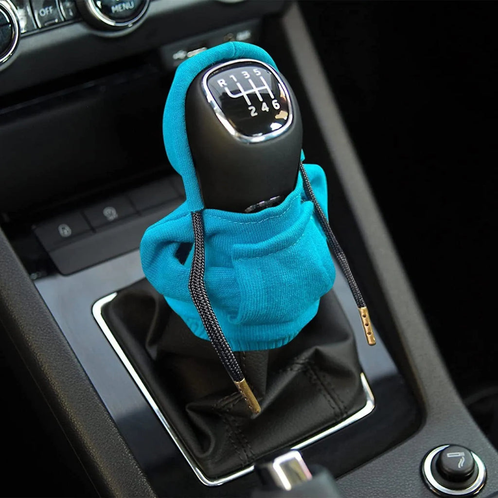 Blue cloth cover fitted over a car gear shift knob on a manual transmission.