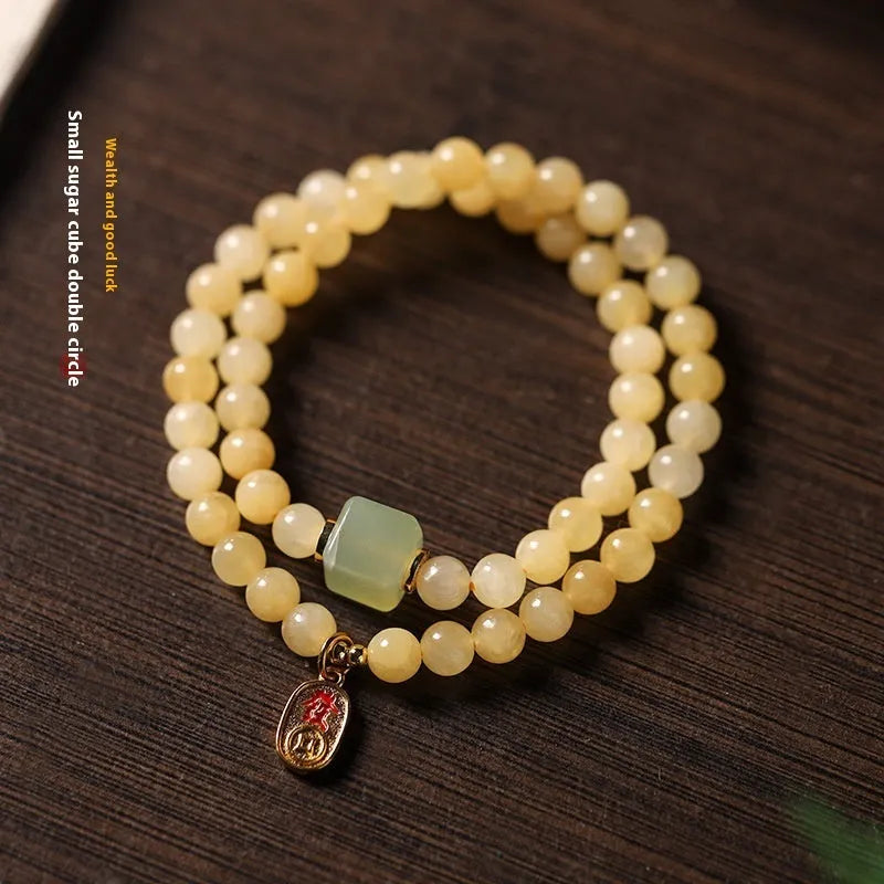 Women's hand-woven topaz bracelet with mantra barrel beads, square sugar beads, and fu charm in yellow jade