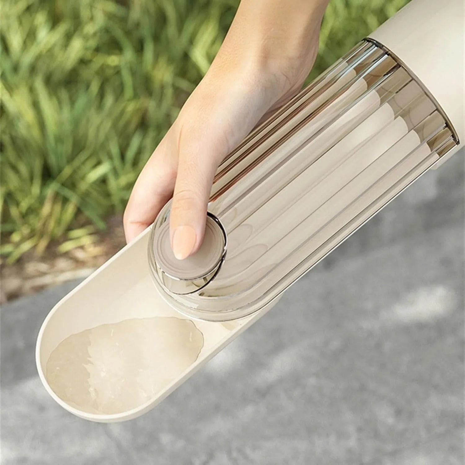 Beige foldable dog water bottle and food dispenser with large drinking opening, shown next to a leash.