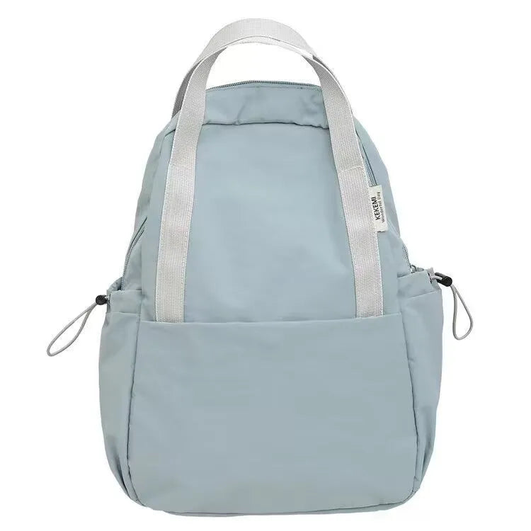 Solid colour nylon backpack in blue with curved straps and a lock, shown in a travel setting.