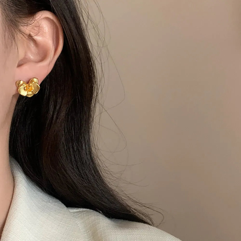 Women's retro flower earrings in copper with gold or silver electroplated finish showing petal detailing