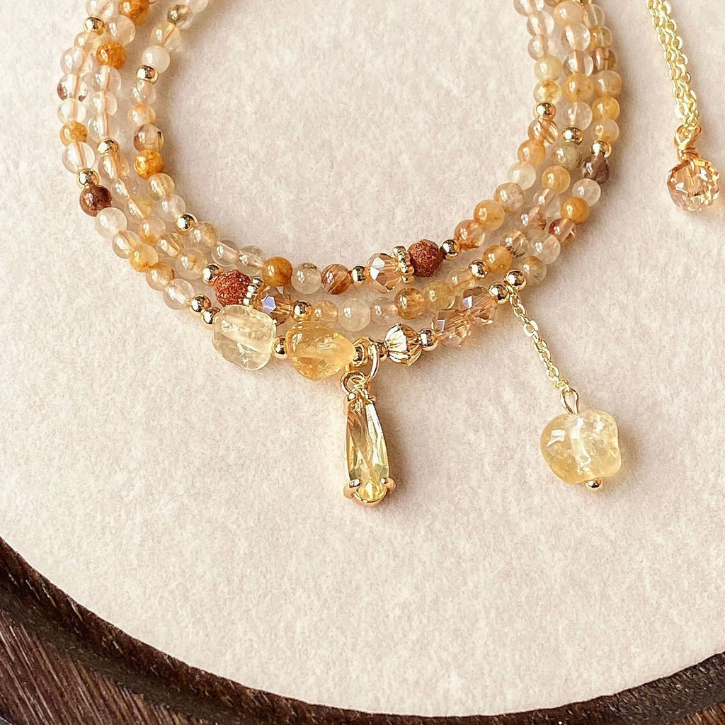 Gold electroplated women's bracelet with three interlinked circles made from natural caramel-coloured citrine and a Saturn decoration.