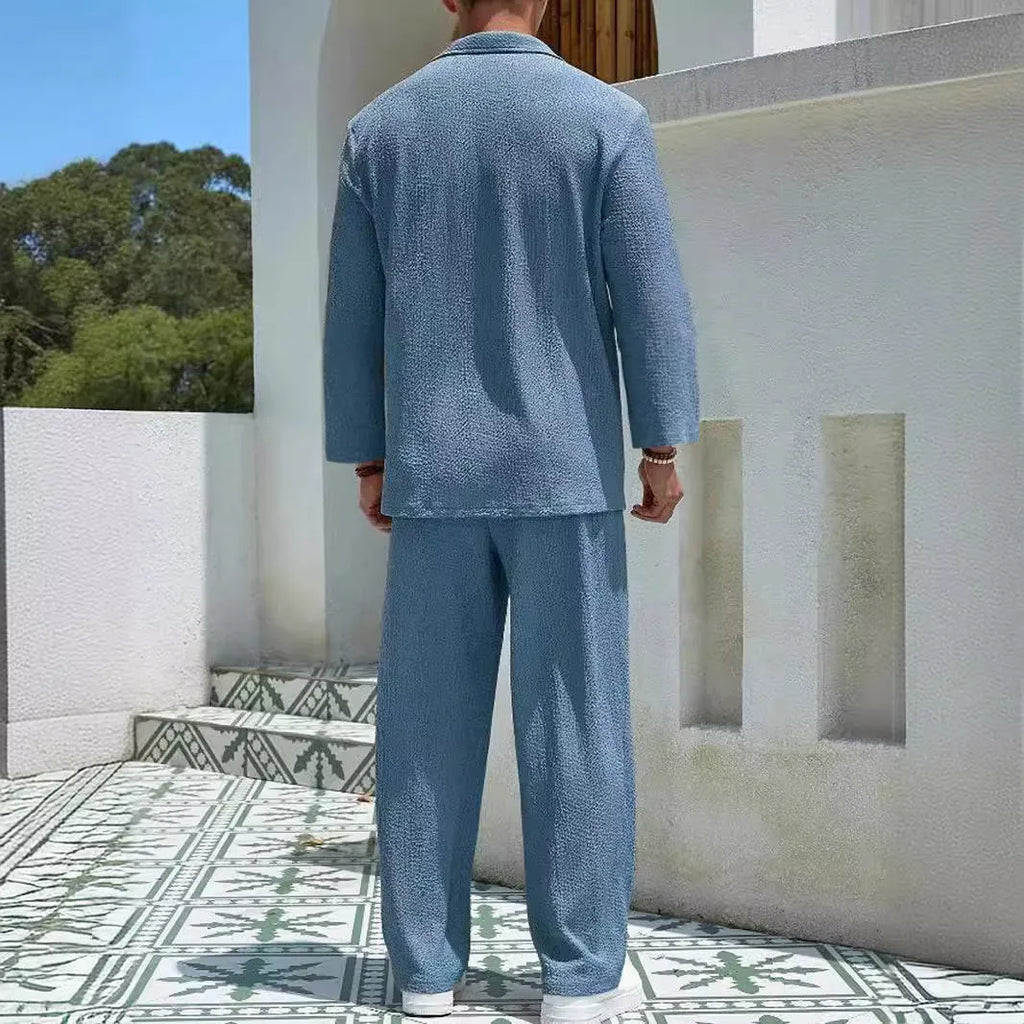 Man wearing a casual lake blue shirt jacket and matching trousers from a polyester commuter suit set.