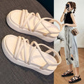 Women's black and beige Roman-style platform wedge sandals on a white background