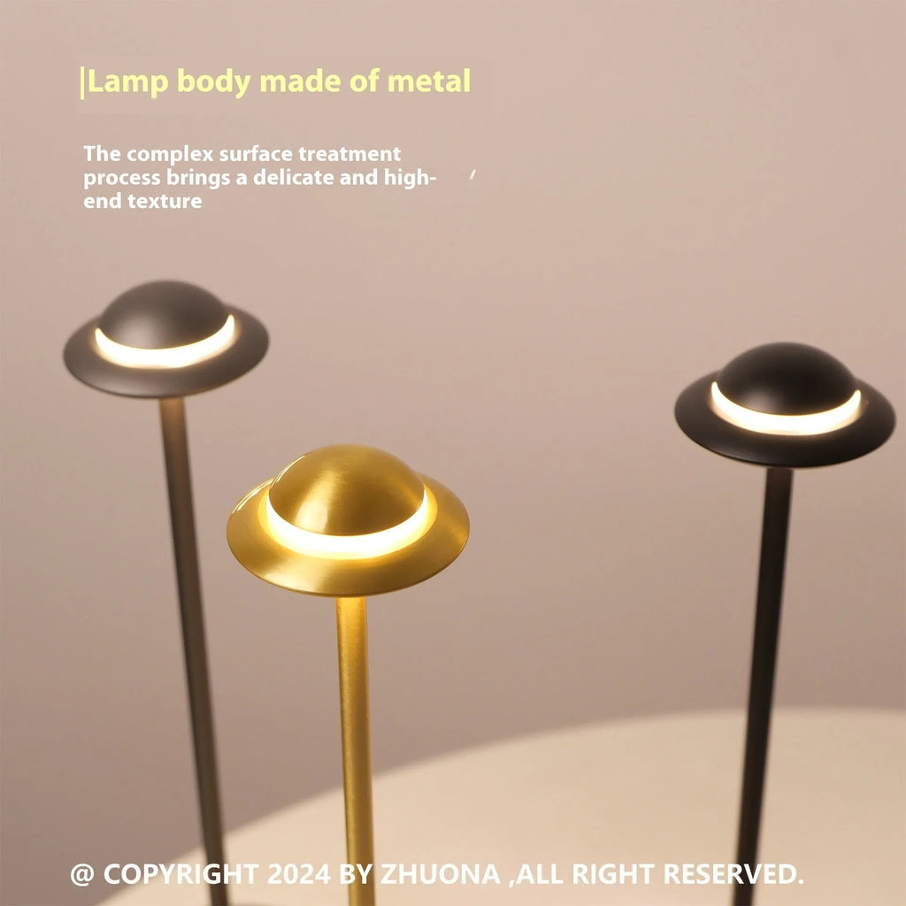 Modern UFO-shaped table lamp in grey with a circular shade on a weighted base, showing touch controls.
