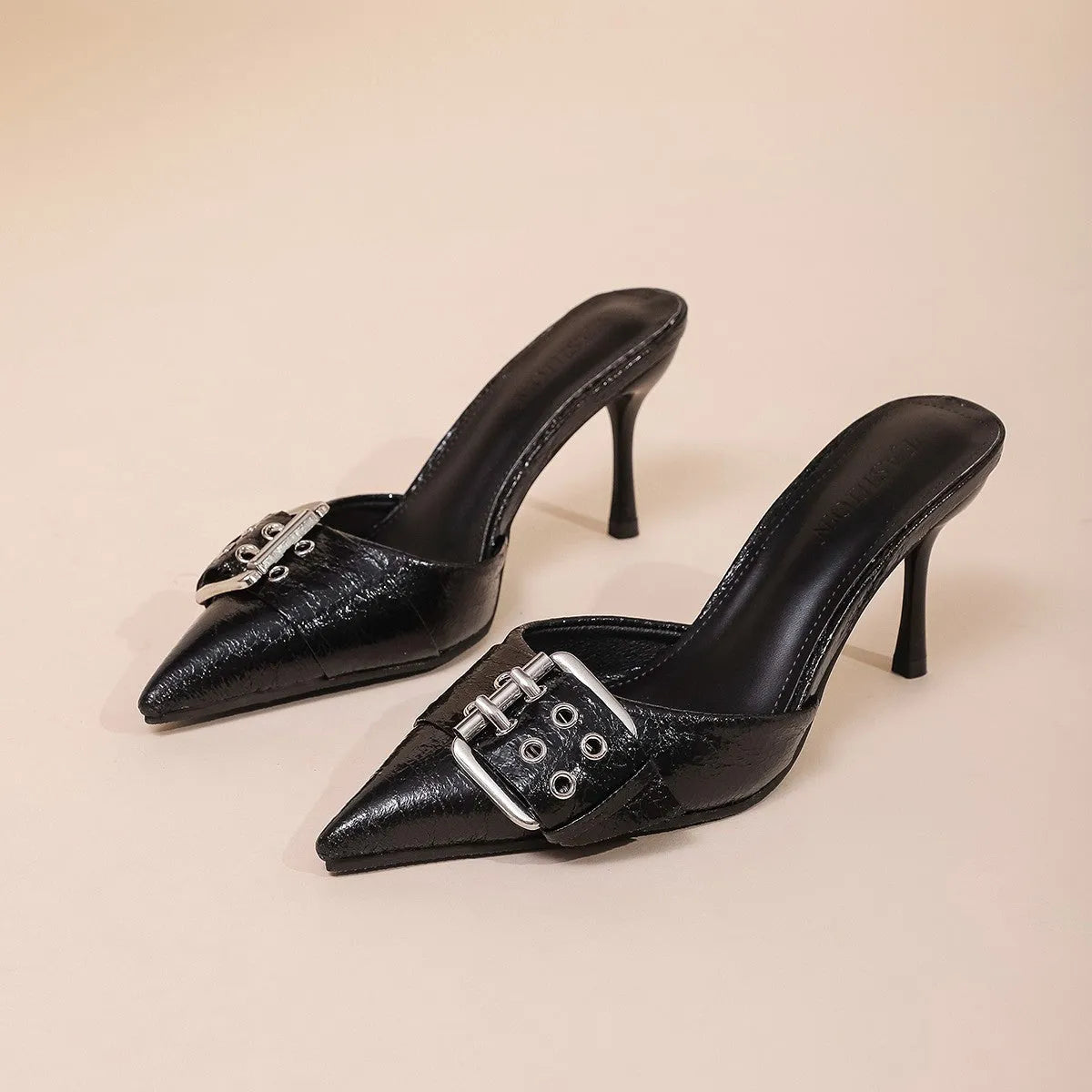 Black women's high heel shoes with pointed toe and buckle strap decoration.