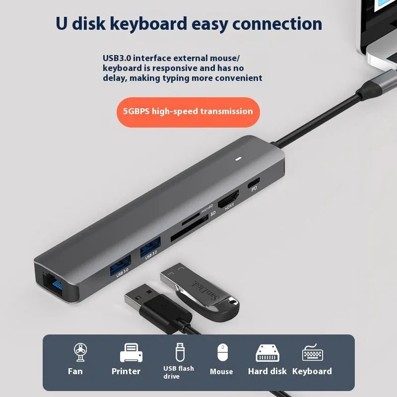 LQT-LH07 7-in-1 USB-C card reader and computer hub on a desk next to a laptop.