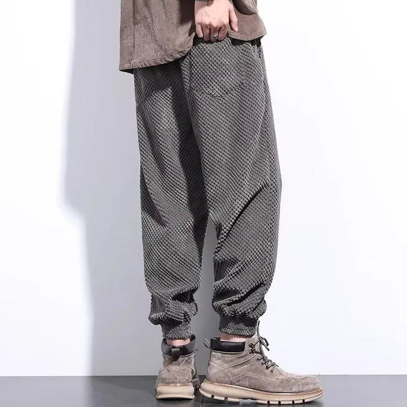 Grey men's sweatpants with ankle ties and a straight leg cut on a neutral background.