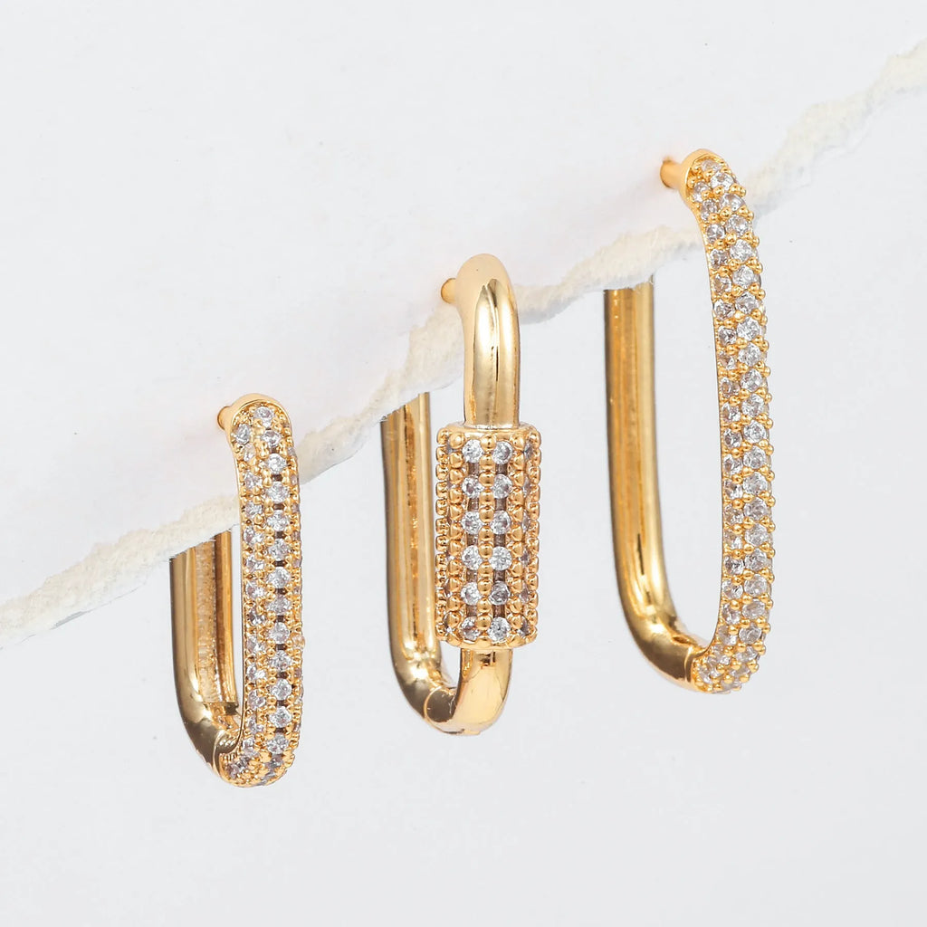 Three geometric copper earrings with inlaid zircon on a square clip, in gold and white finishes.