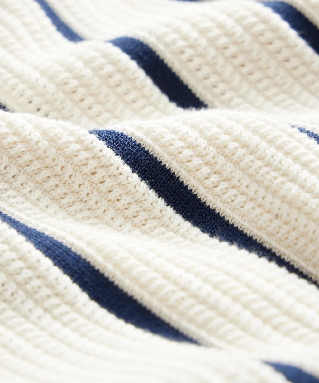 Men's white British style knitted short sleeve top with lapel and asymmetric stripes.
