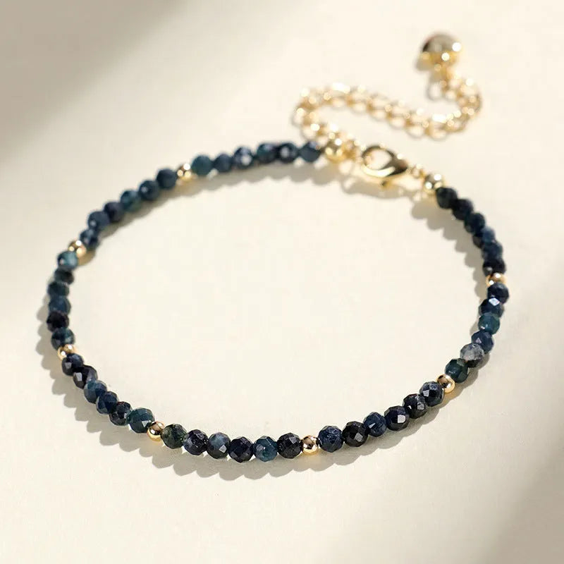 Blue tourmaline bracelet with 3mm beads and silver spacer beads on wrist