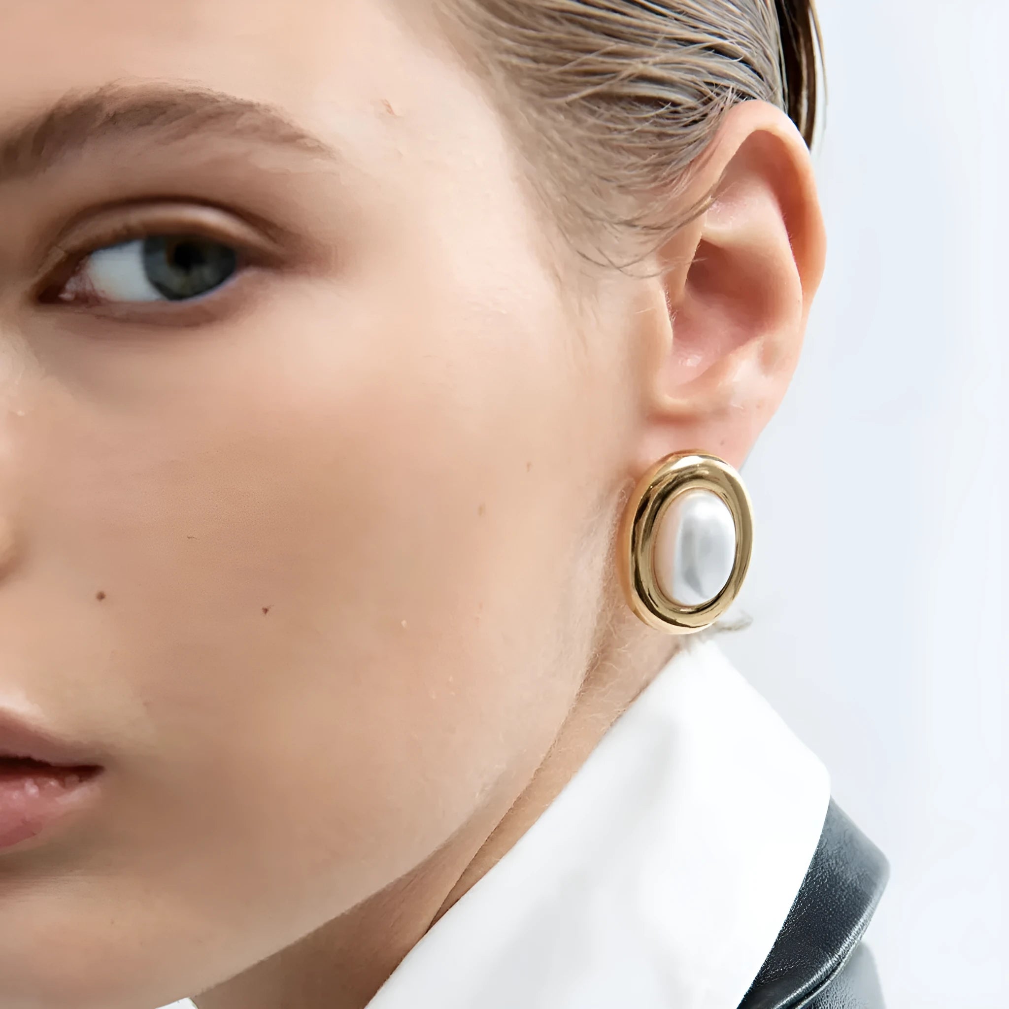 A pair of stainless steel stud earrings with a vintage pearl centre in a silver-tone finish.
