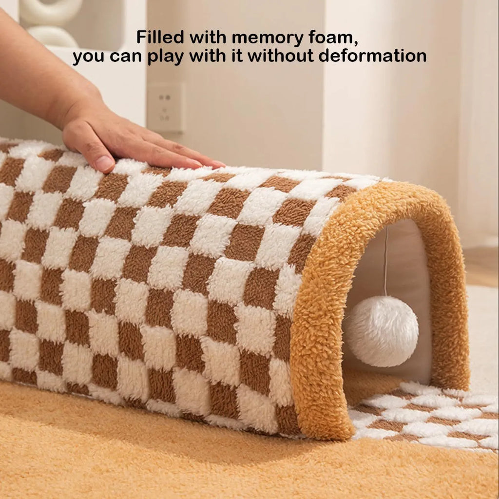 XL fan-shaped plush pet bed with a tunnel, in a plaid coffee colour, on a wooden floor.