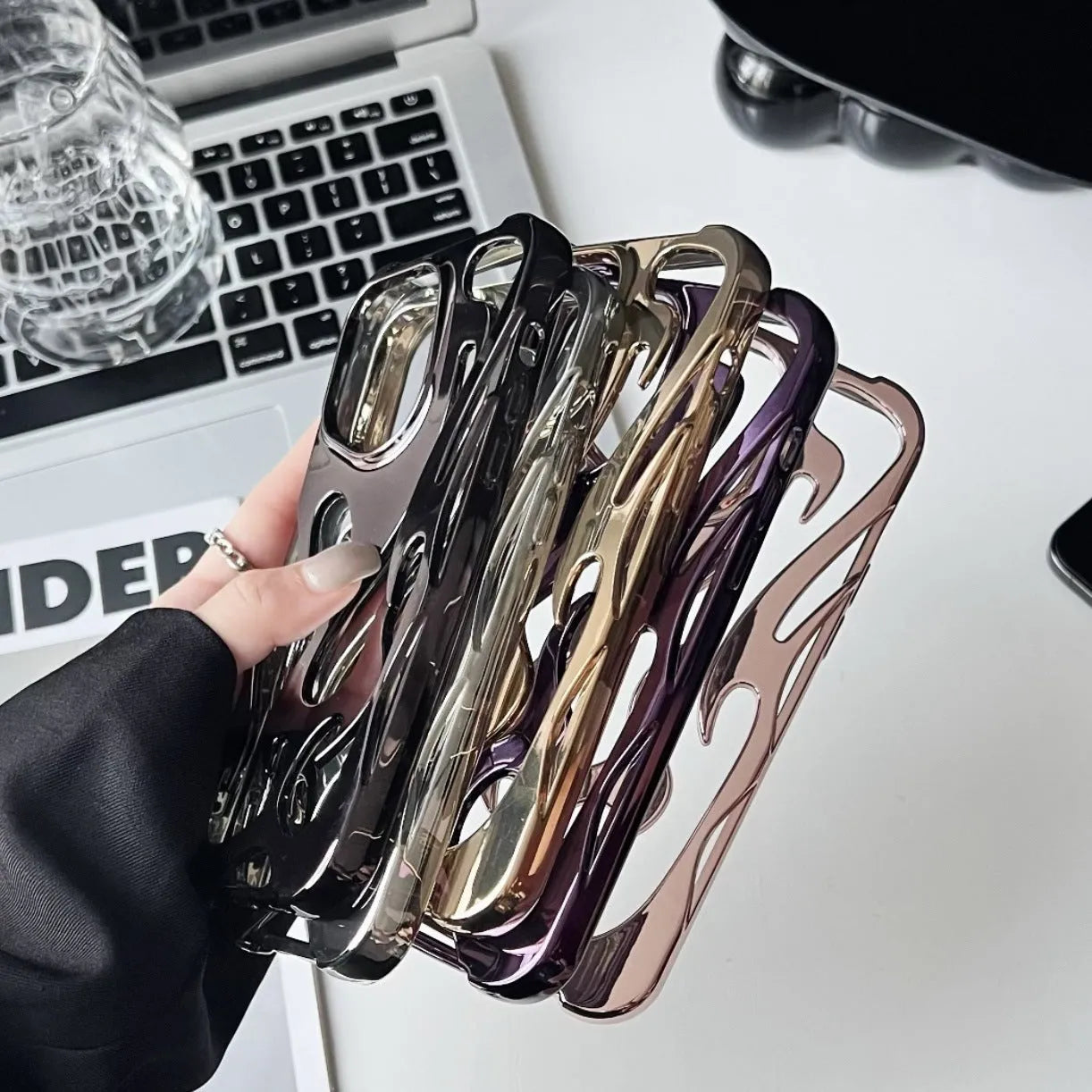 Electroplated hollow flame pattern mobile phone case for iPhone on a dark background, showing silver metallic finish.