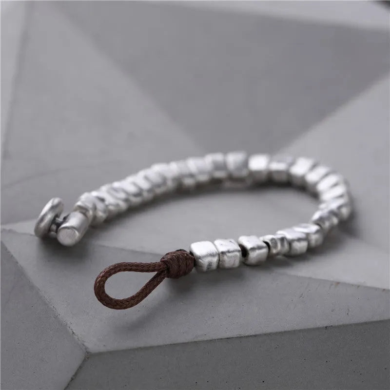 Handmade women's bracelet with irregular silver square and wood on a black elastic band.