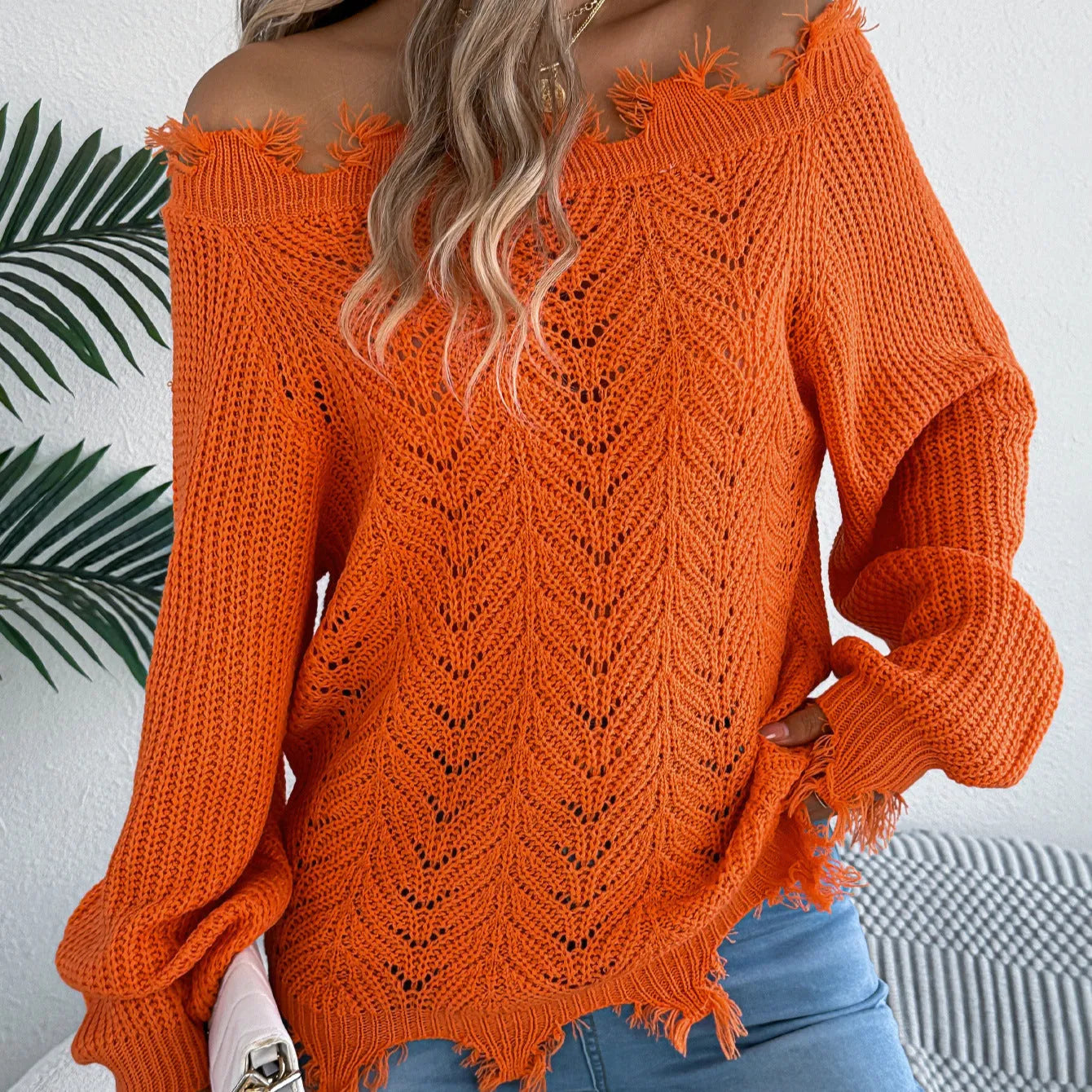 White hollow-out off-the-shoulder long sleeve pullover sweater laid flat.