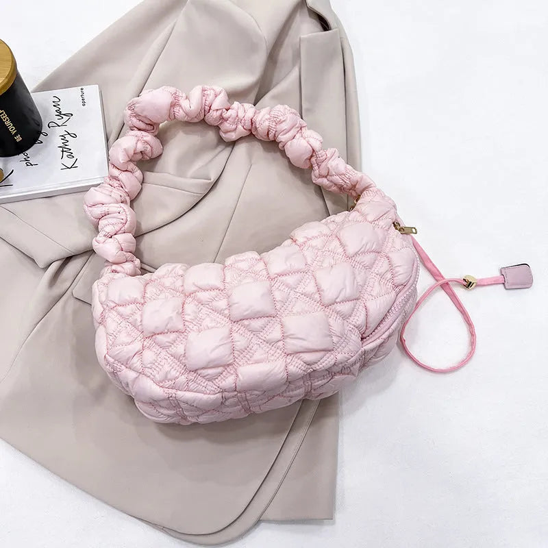 Women's light beige nylon cloud underarm messenger bag with a long adjustable shoulder strap.
