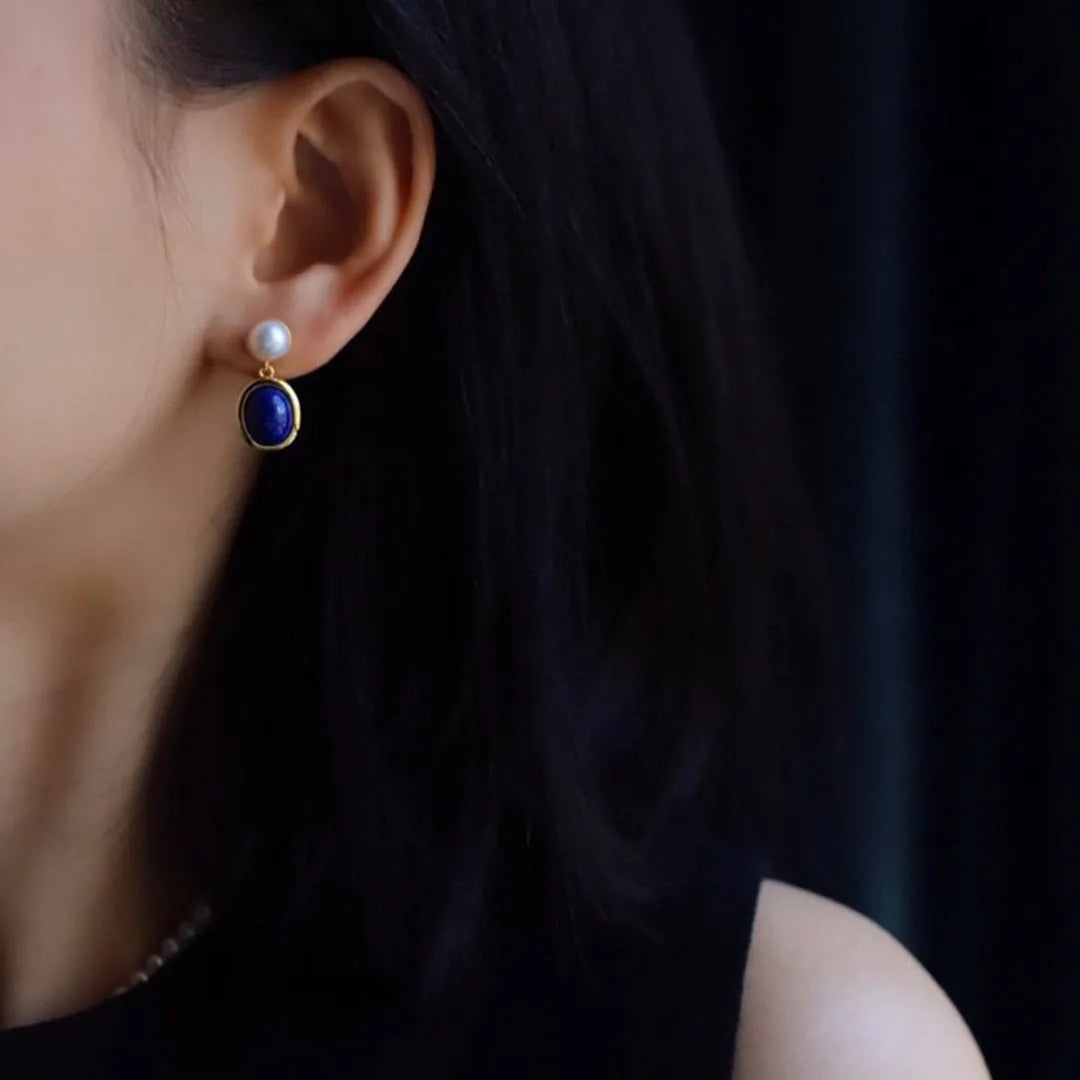 A pair of sterling silver drop earrings with a blue lapis lazuli pearl and auspicious patterns.
