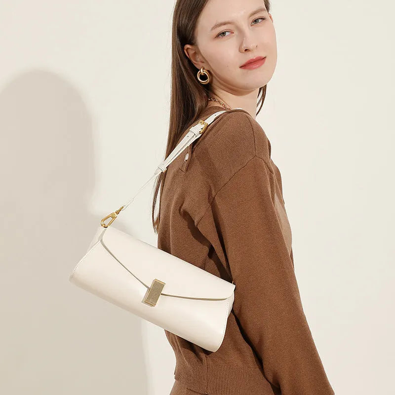 Cowhide leather cross-body shoulder bag in pillow shape with clamshell opening showing internal phone and document pockets