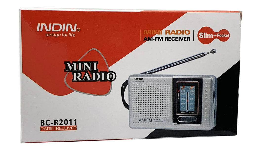 Portable silver grey FM AM radio on table, compact ABS body with built-in speaker and dial controls