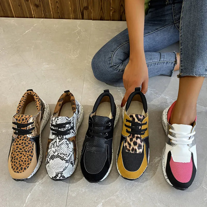 Women's suede sneakers with a wedge heel in leopard print, shown on a foot.
