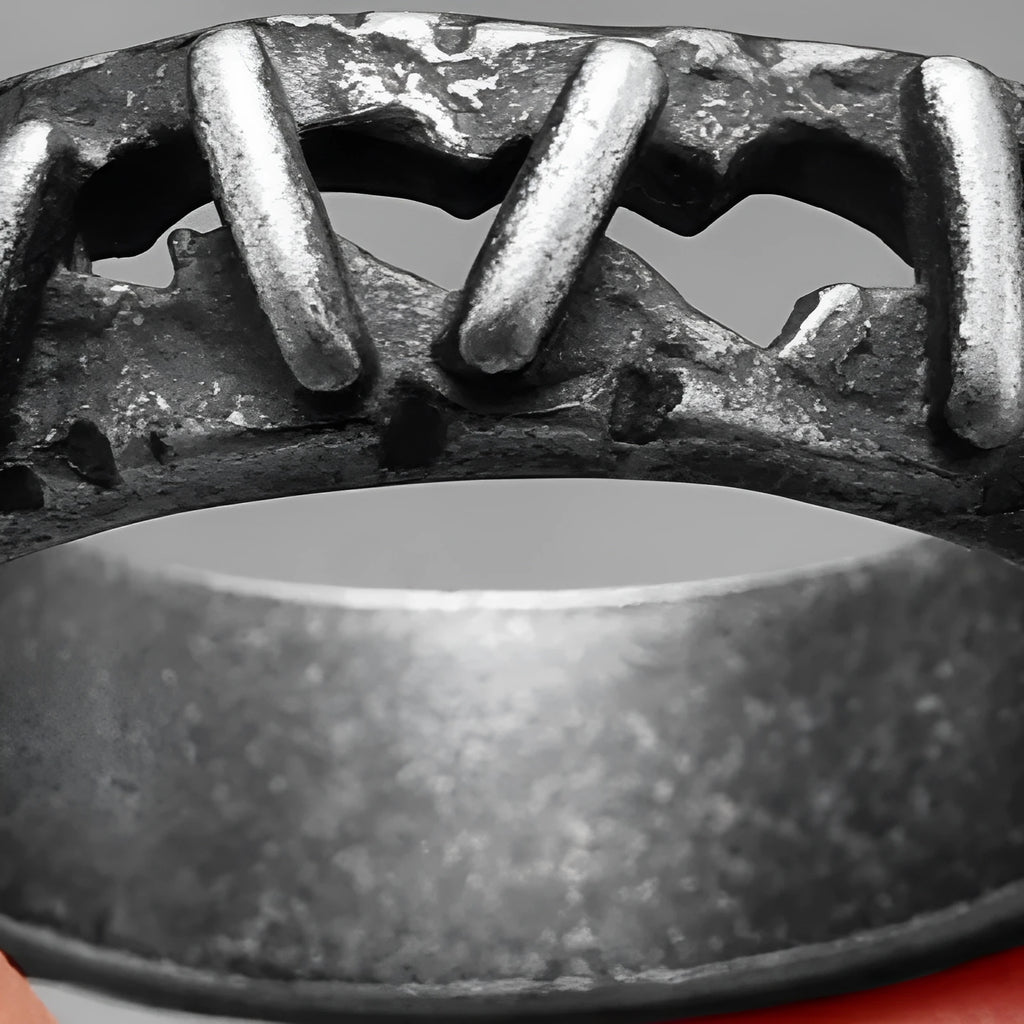 Close-up of a stainless steel double ring with dark punk stitching-style texture on the band.