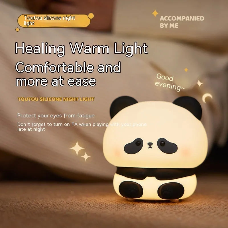 Cute panda LED night light with soft silicone cover, USB rechargeable, featuring colourful lighting modes on a bedside table.