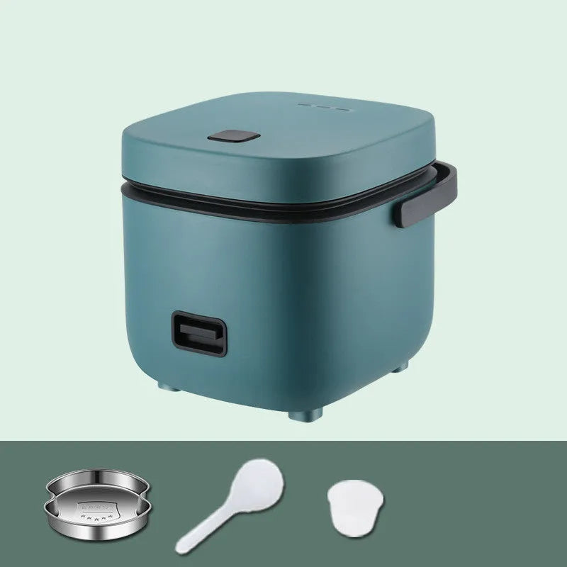 Green mini rice cooker 1.2L with steaming plate, rice spoon and measuring cup on countertop