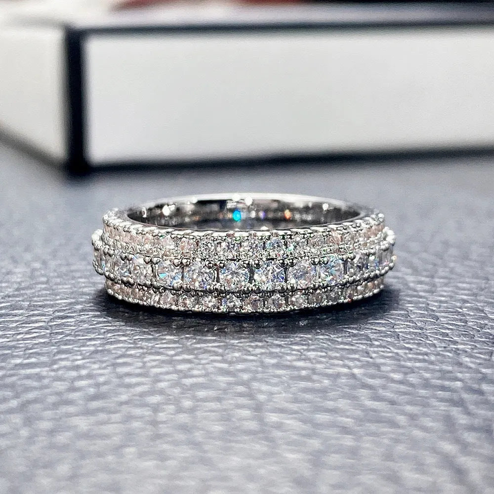 Geometric triangle zircon engagement ring in copper on a finger, showing white gold colour finish.