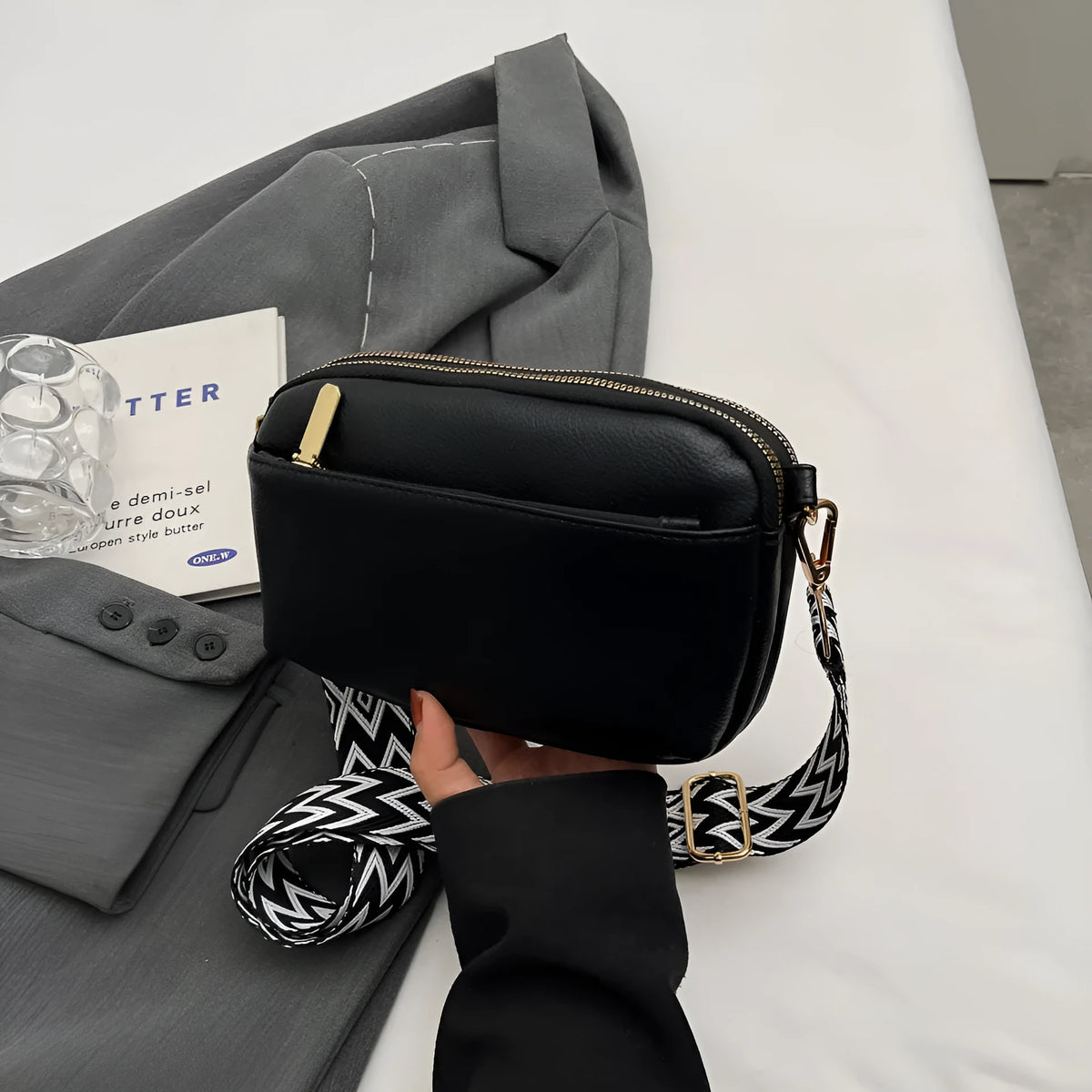 Women's cross-body bag in black, urban simplicity style, with visible sewing thread and sandwich pocket on front.