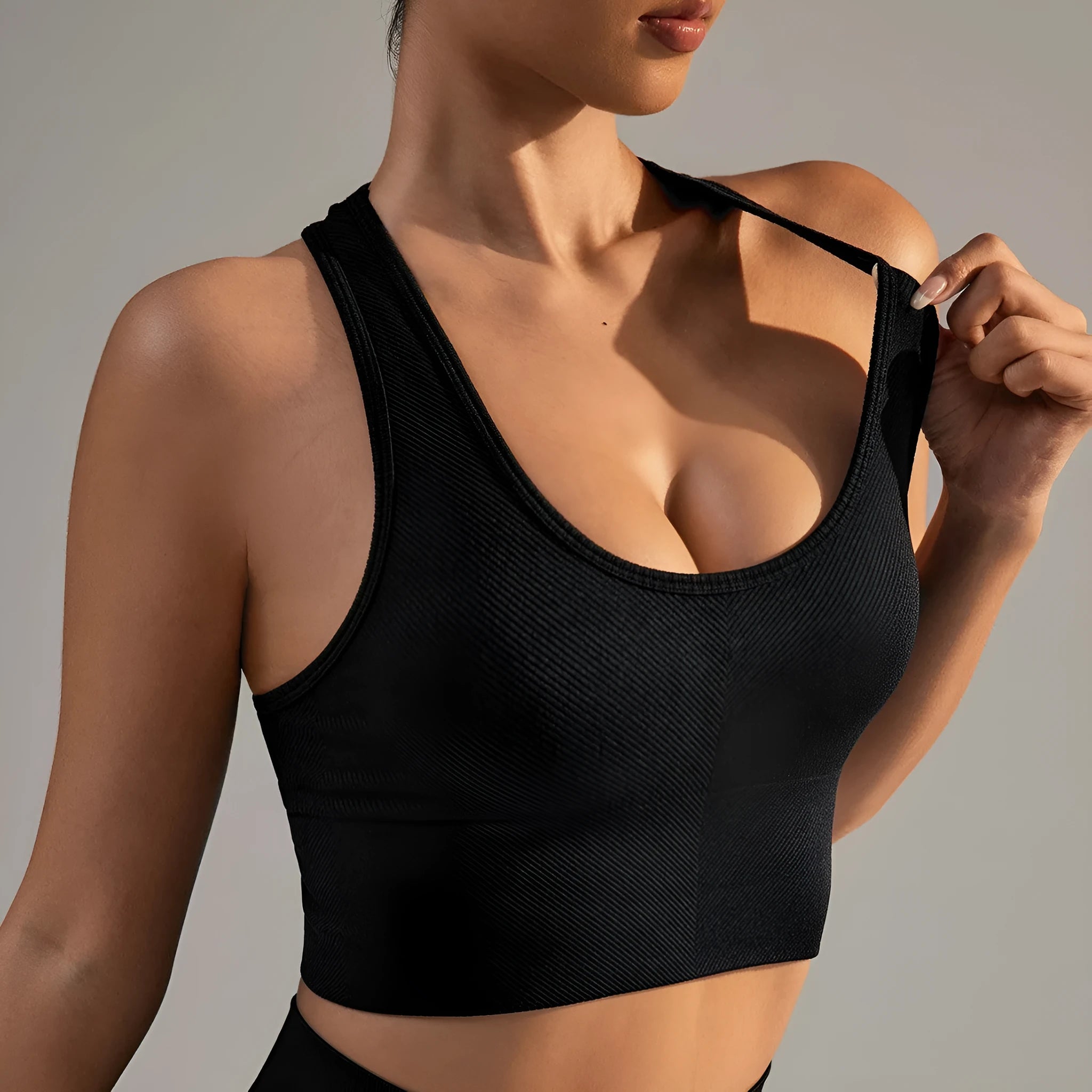 Black women's cross-back sports bra with moulded cups on a hanger