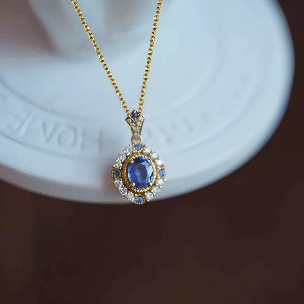 Yellow gold-colour adjustable box chain necklace with a mixed gemstone inlaid pendant on a white background.