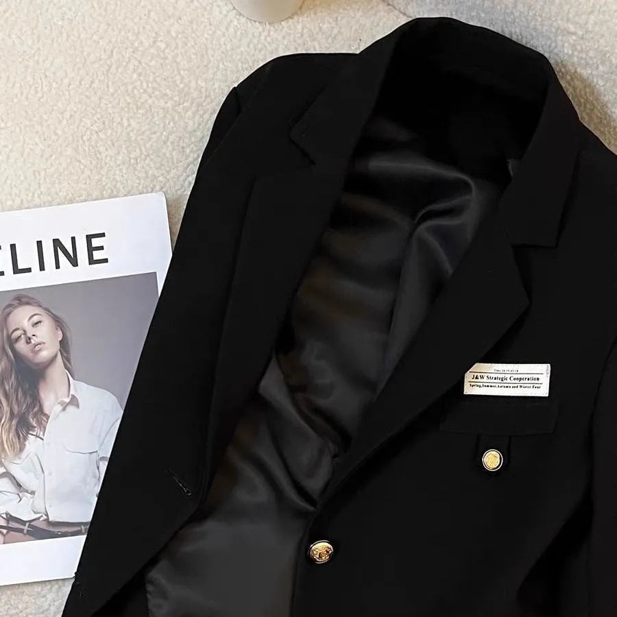 Black women's loose-fit short suit coat with regular sleeves and pockets.
