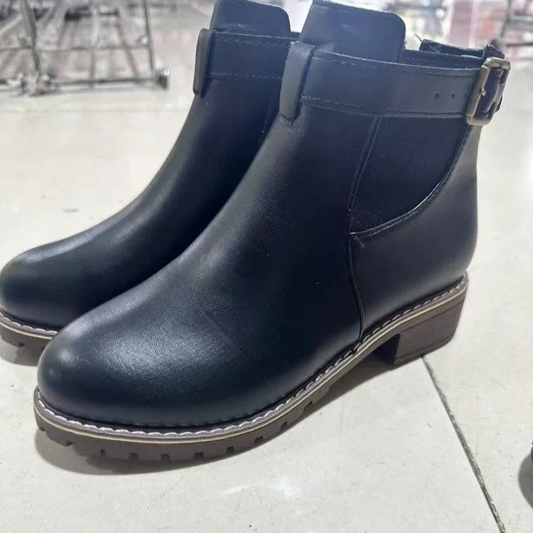 Black round toe women's ankle boot with a decorative metal belt buckle on the side.