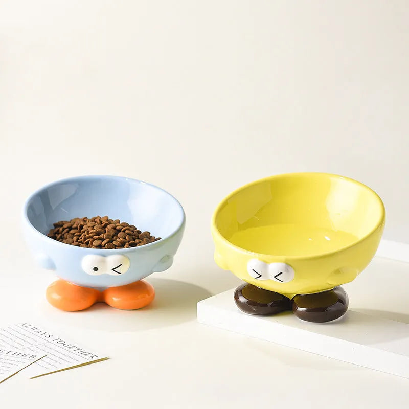 Ceramic slanted pet bowl with cute expression design in blue, yellow, and set colours for cervical spine support.